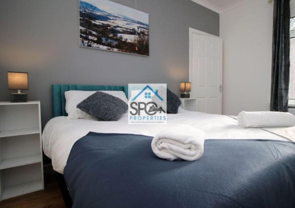 1 dormitorio con 2 camas y 1 toalla en la cama en Modern 4BR Home-7 Guests-Business-Families-Netflix-Free Parking & WiFi, en Pontnewynydd