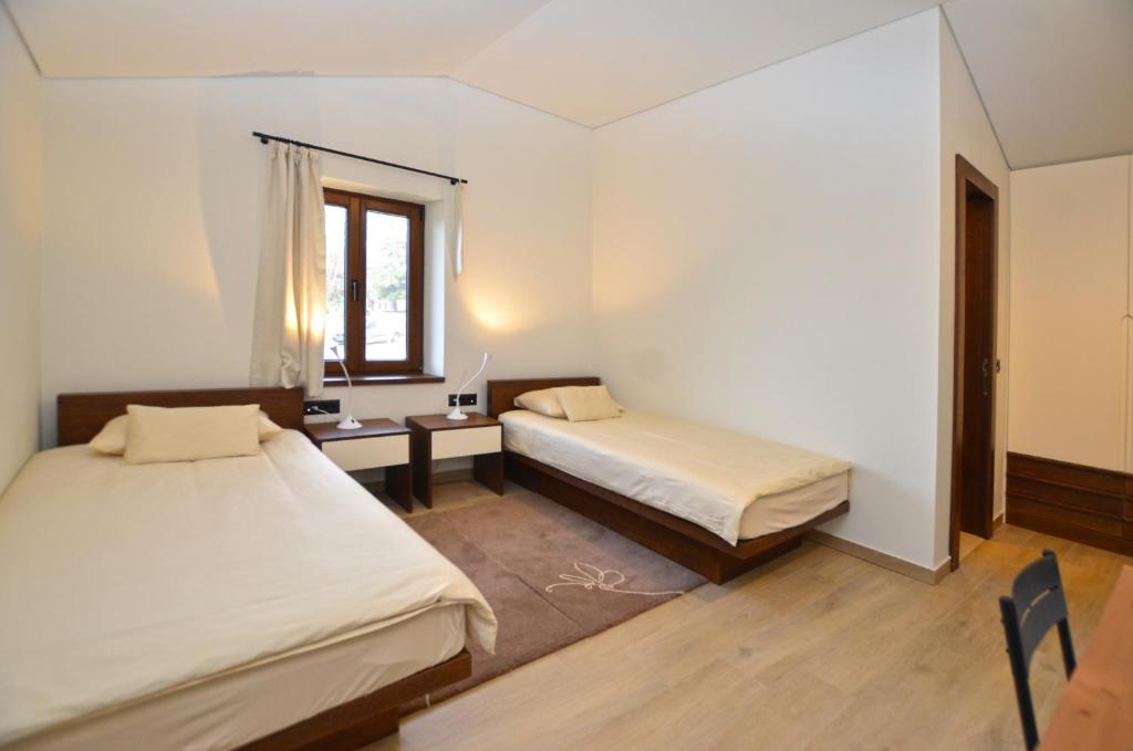 a room with two beds and a desk and a window at Casa Farfalla in Bale