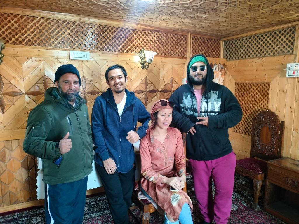 a group of people posing for a picture in a room at Pasadona Floating Houseboat in Srinagar