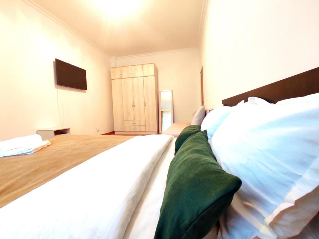 1 dormitorio con 2 camas blancas y puerta en Апартаменты с видом на EXPO в ЖК EXPO New Life, en Taldykolʼ