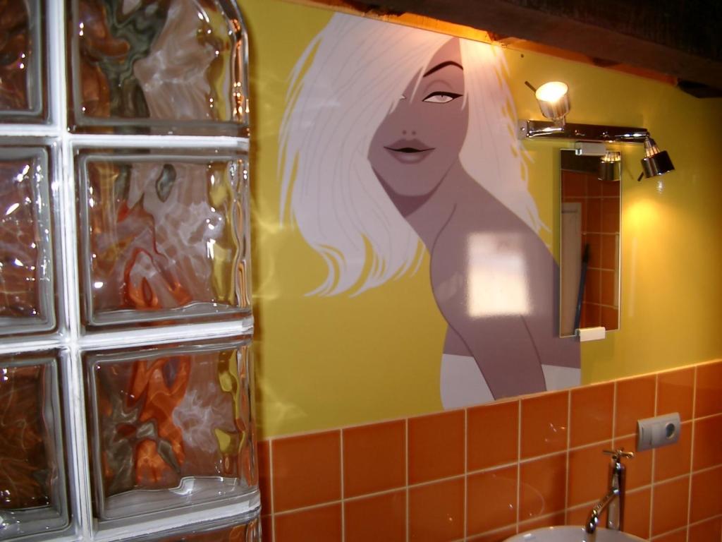 a bathroom with a picture of a woman in a mirror at Apartamento La boqueria Atic in Barcelona