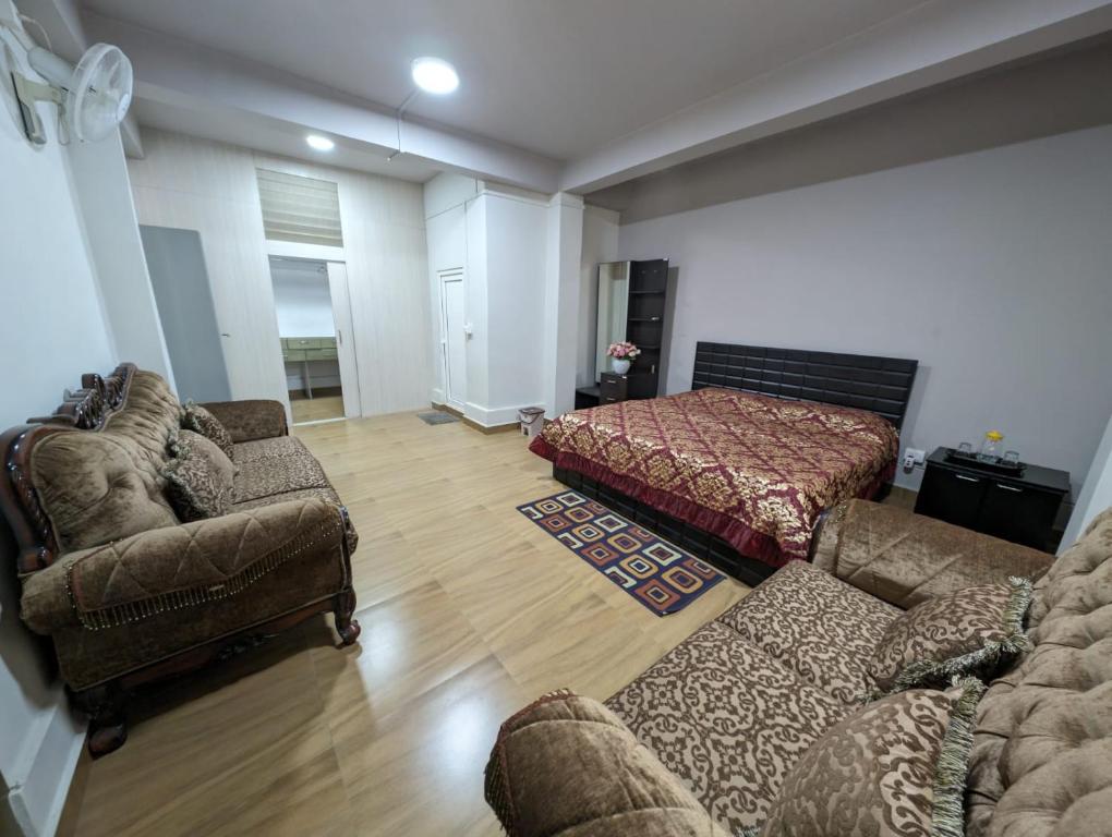 een woonkamer met een bank en een bed bij RT Mutbu in Aizawl