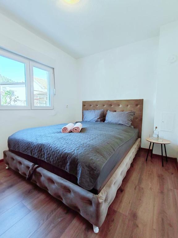 a bedroom with a large bed with a wooden floor at Apartment Libar with Terrace and private Parking in Mostar
