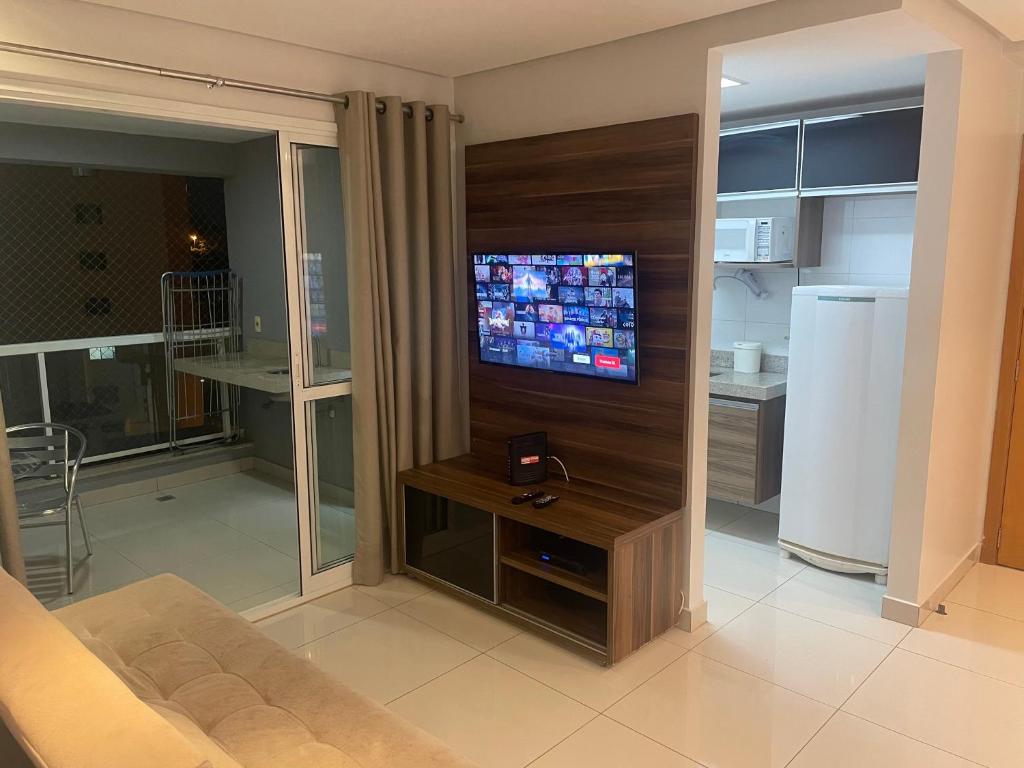 uma sala de estar com uma TV de tela plana na parede em Gift Home Residence 6ºAndar Setor Oeste em Goiânia