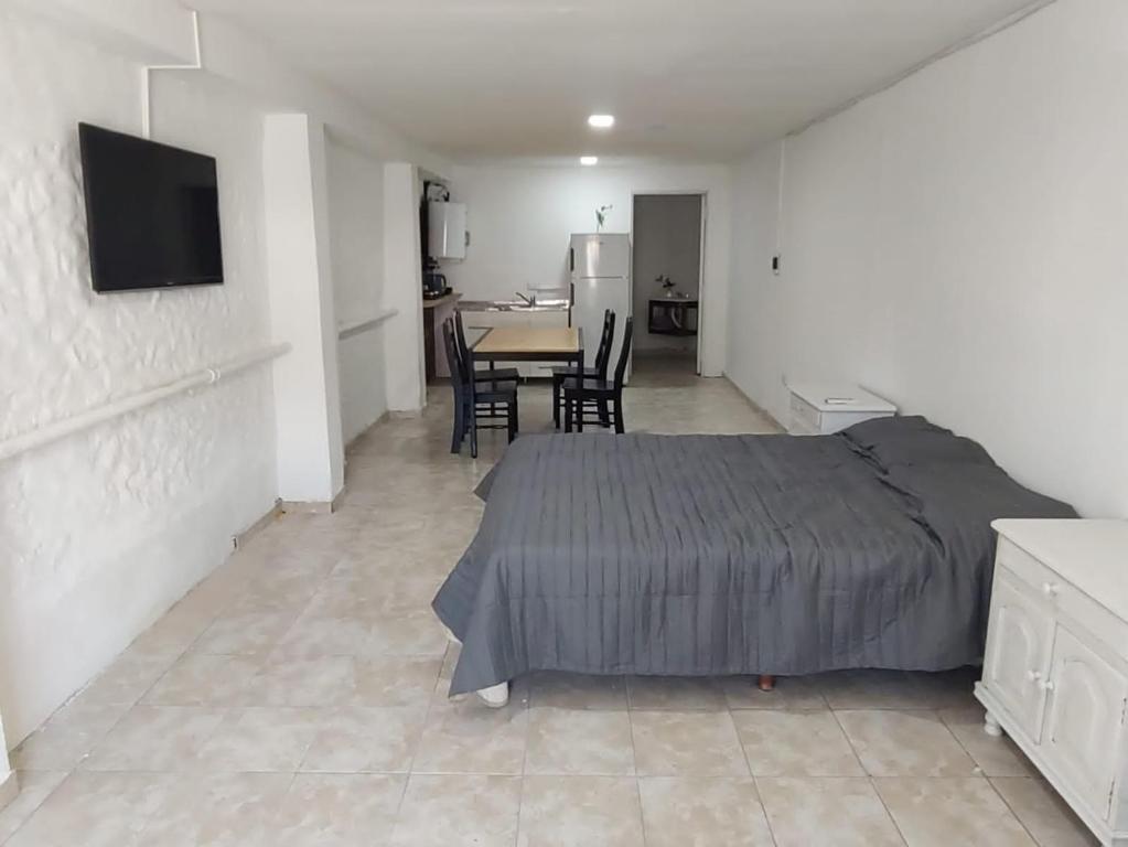 a bedroom with a bed and a table and chairs at Departamento Temporario Bianchi in Santiago del Estero