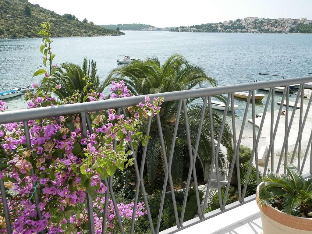 einen Balkon mit Blick auf das Wasser und die Blumen in der Unterkunft Ferienhaus Dijana in Rogoznica