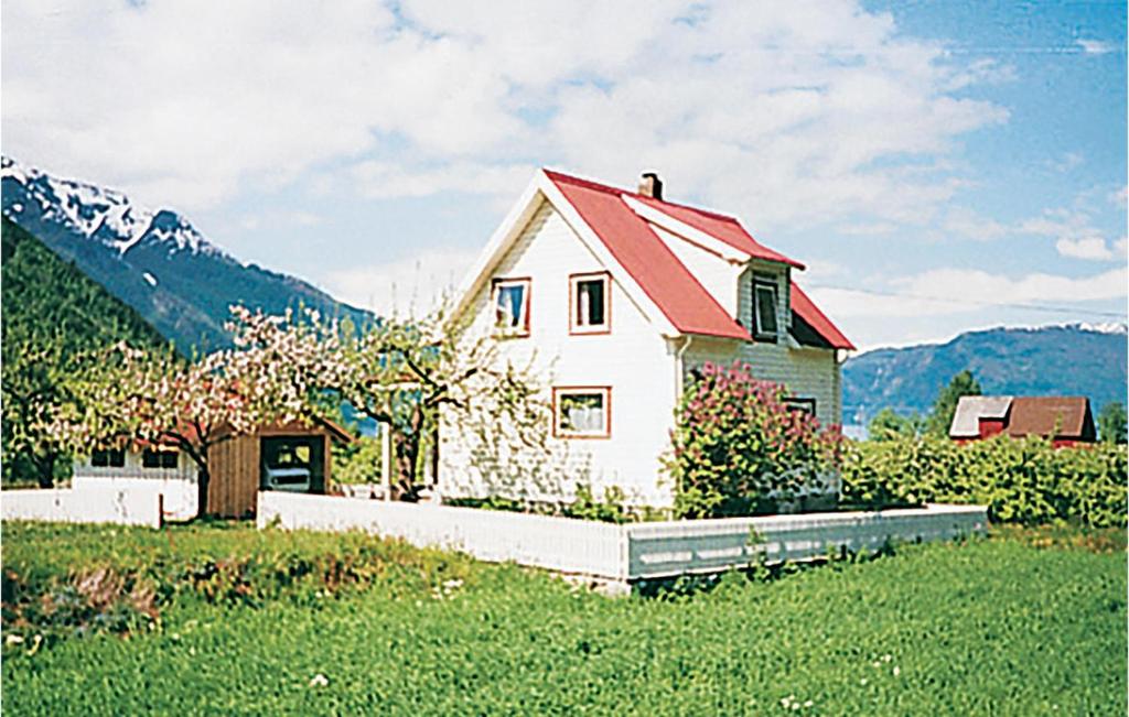 a white house with a red roof in a field at Solhaug in Fresvik