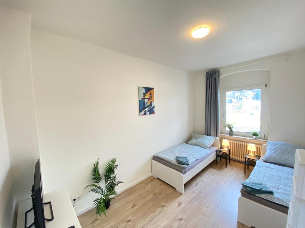 een kleine kamer met 2 bedden en een raam bij Gemütliches Apartment Remscheid in Remscheid