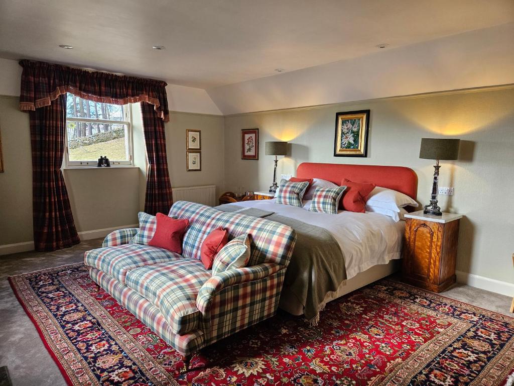 een slaapkamer met een bed en een bank bij Craggan in Ballater