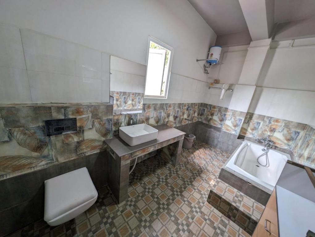 een badkamer met een wastafel, een toilet en een bad bij RT Mutbu in Aizawl