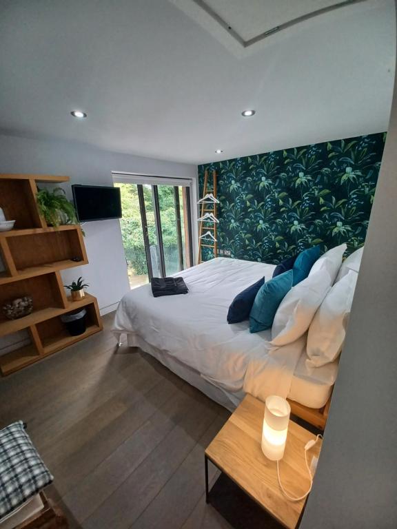 a bedroom with a large bed with blue pillows at Pound Orchard Bed and Breakfast in Petersfield