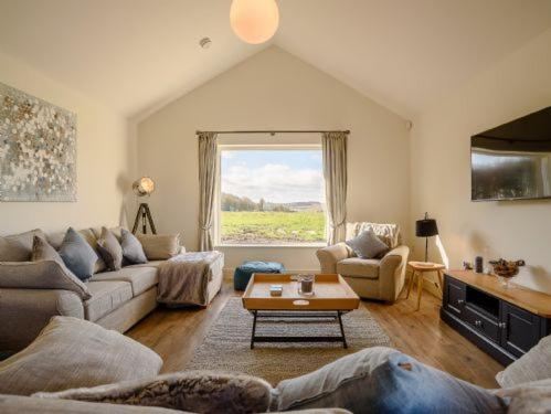 een woonkamer met een bank en een tafel bij Gallops in East Ilsley