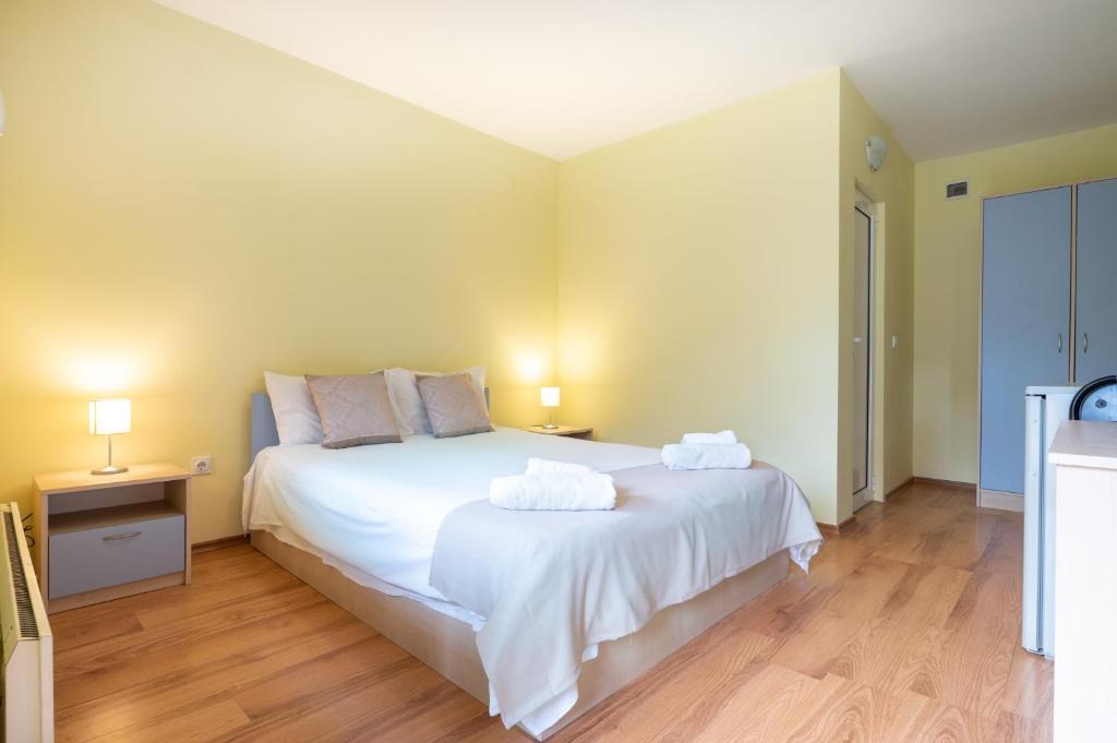 um quarto com uma grande cama branca com duas toalhas em Вили Тихия Кът em Ribarica