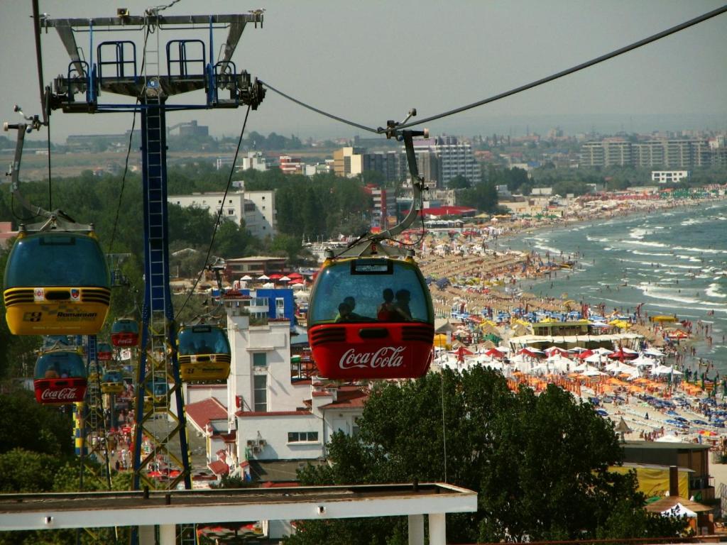 three cocacola cable cars flying over a beach at Black Sea Coast Apartment in Constanţa