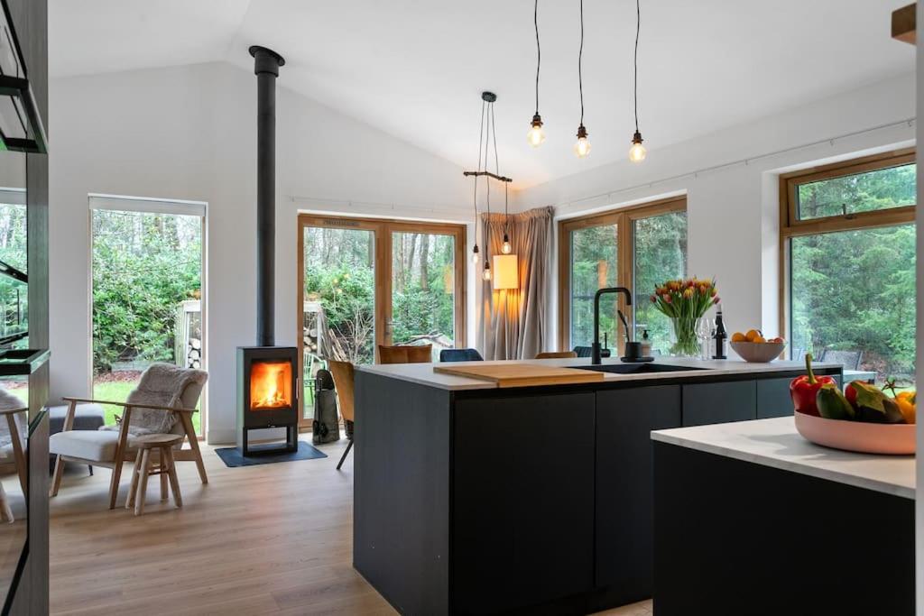 a kitchen with a kitchen island with a stove at Nieuwe luxe villa in het bos in Zorgvlied