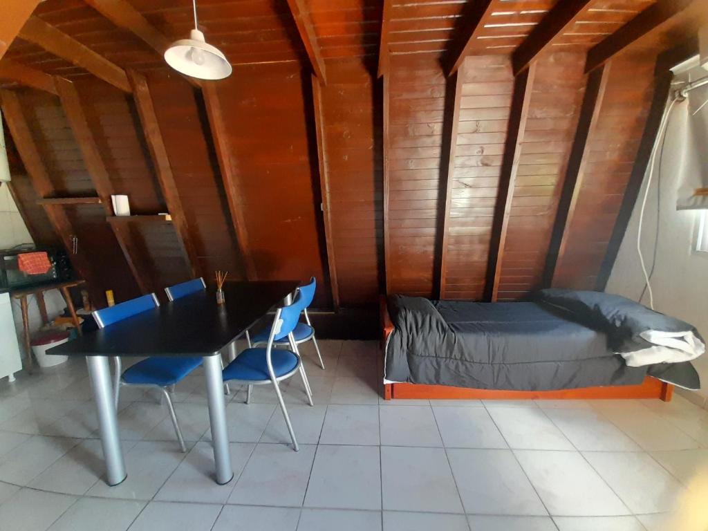 ein Zimmer mit einem Bett, einem Tisch und Stühlen in der Unterkunft Chacaimanta RIVERA in Rivera