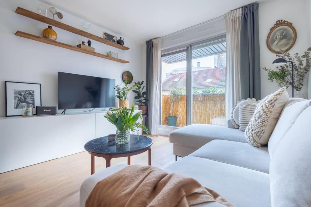 Hotel GASPAR - Joli nid douillet proche de Paris avec balcon, a living room with a white couch and a table at GASPAR - Joli nid douillet proche de Paris avec balcon in Boulogne-Billancourt