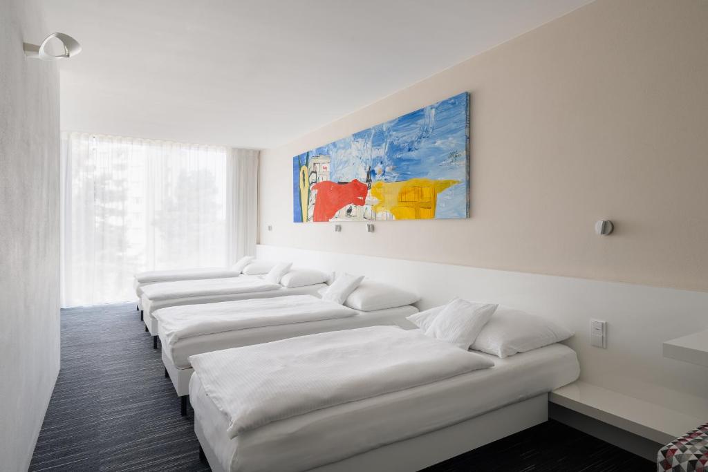 a row of white couches in a room at Fabrika Hotel in Humpolec