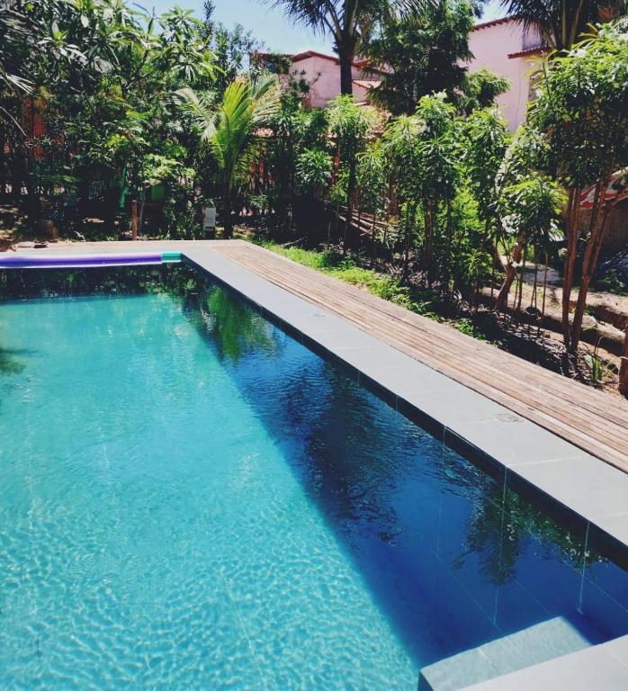 a swimming pool with blue water and a wooden path at Dellacasa in Jericoacoara