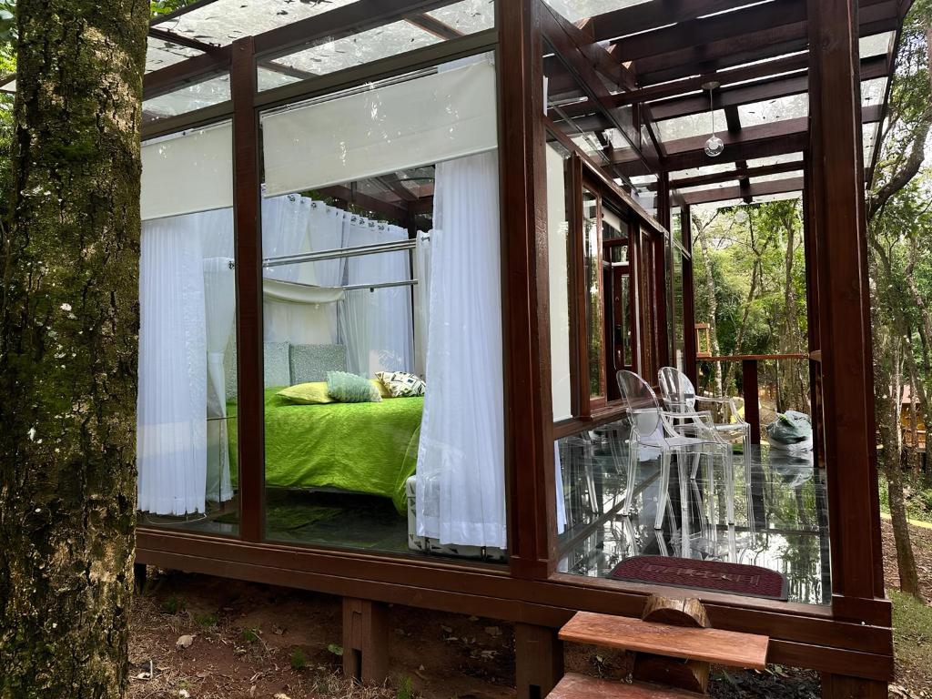 ein Glashaus mit einem Bett in einem Wald in der Unterkunft Casa de Vidro - Vila Mágica in Bueno Brandão