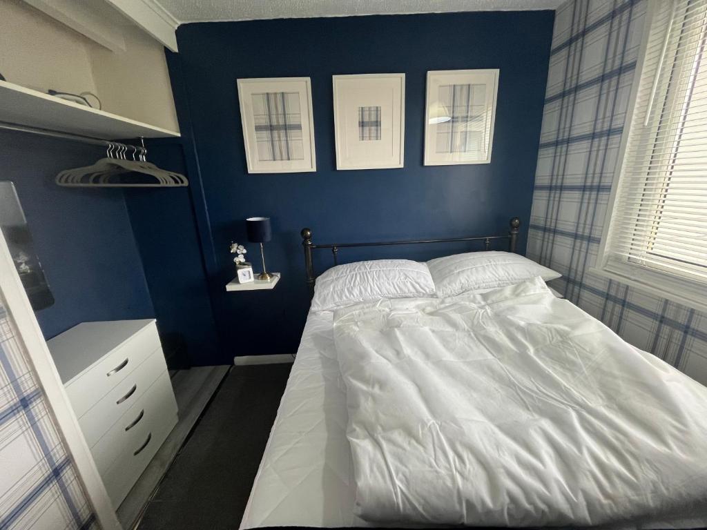 um quarto com uma cama com uma parede azul em Holidayz, Chalet 58, Hemsby - Beautifully presented two bed chalet, sleeps 4, pet friendly, close to beach em Hemsby