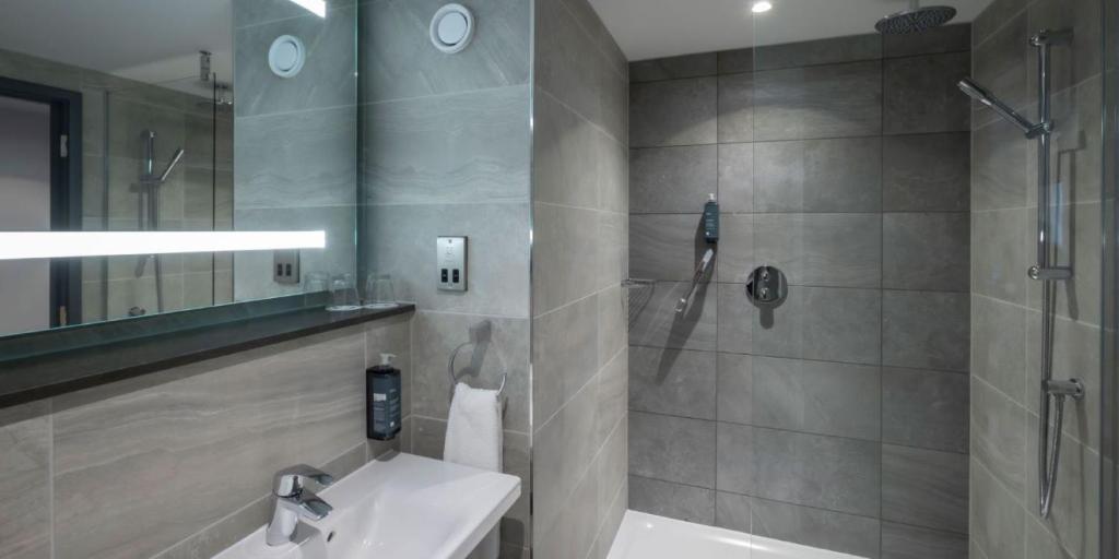 a bathroom with a sink and a shower at Maldron Hotel Brighton City Centre in Brighton & Hove