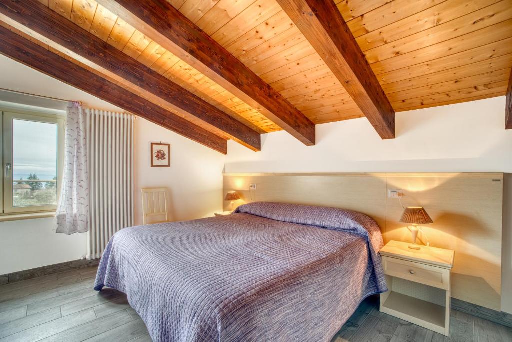a bedroom with a bed and a wooden ceiling at Casavacanzelemore - Casa Zoe in Valfabbrica