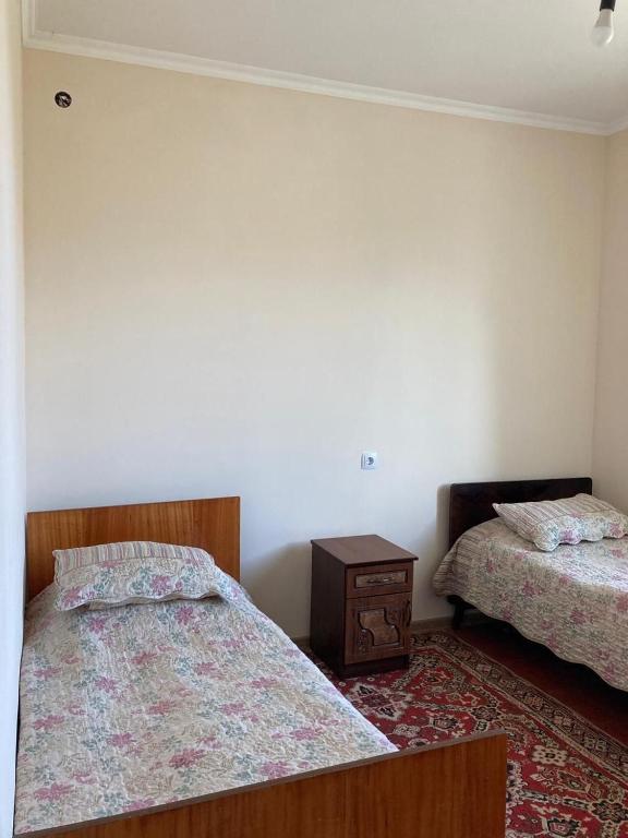 a bedroom with two beds and a night stand at Тигран in Sevan