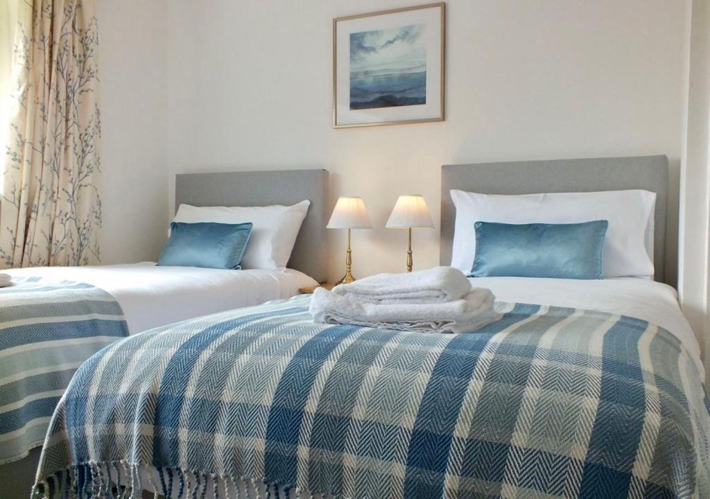 1 dormitorio con 2 camas con sábanas azules y blancas en Port View House, en Cardiff