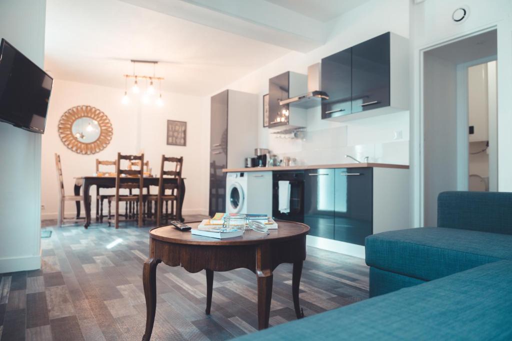 un salon avec un canapé bleu et une table dans l'établissement Le Cube Soma - Confortable T3, à Tours