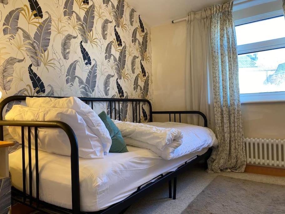 a small bed in a room with a window at Luxurious quirky 2bedroom house in Southampton