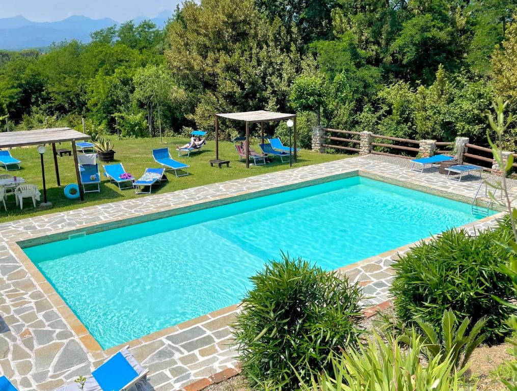 einen Pool in einem Garten mit Stühlen und einem Pavillon in der Unterkunft B&B Alloro in Capannori