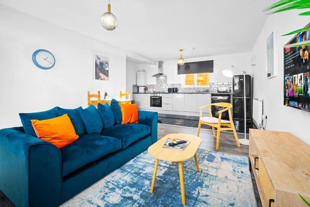 a living room with a blue couch and a table at Stylish New Apartment - Free Wifi & Netflix - 3MH in Old Hill