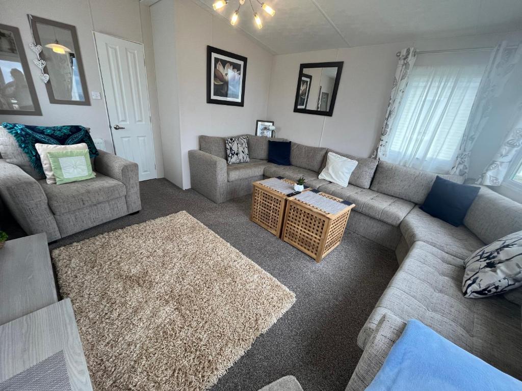 a living room with a couch and a table at Heron, Sea View, Scratby - California Cliffs, Parkdean, sleeps 6, bed linen and towels included, pet free, onsite entertainment available in Scratby
