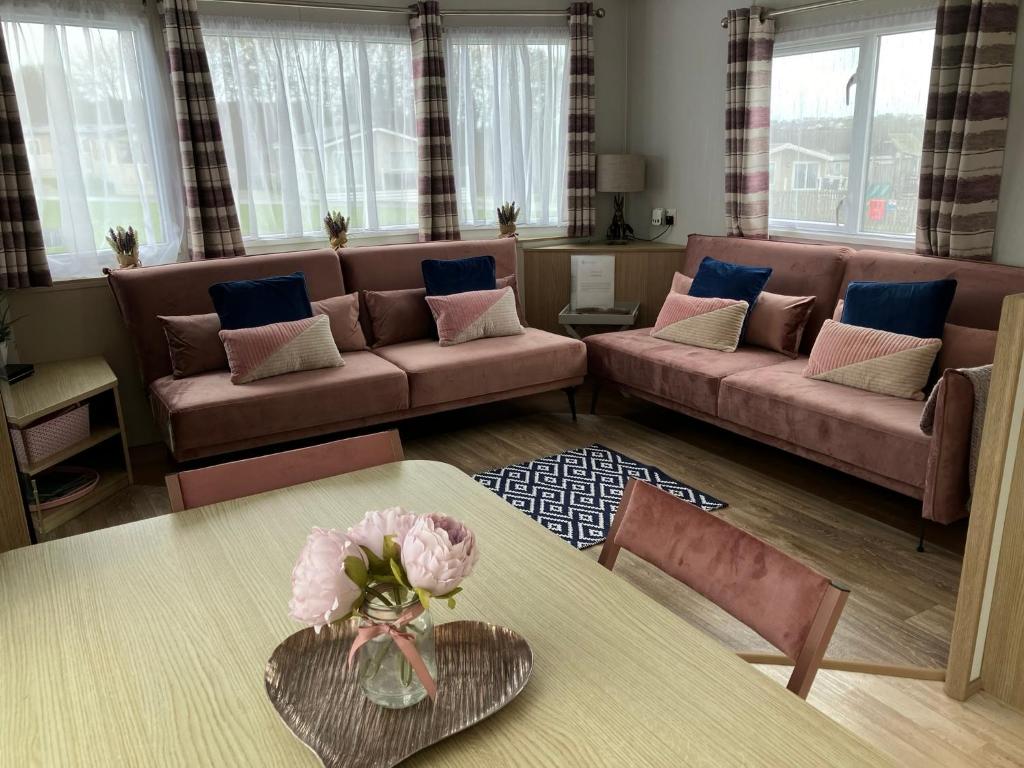 un soggiorno con divano e tavolo di Woodberry (Acorn Caravan Holidays Newquay) a Crantock