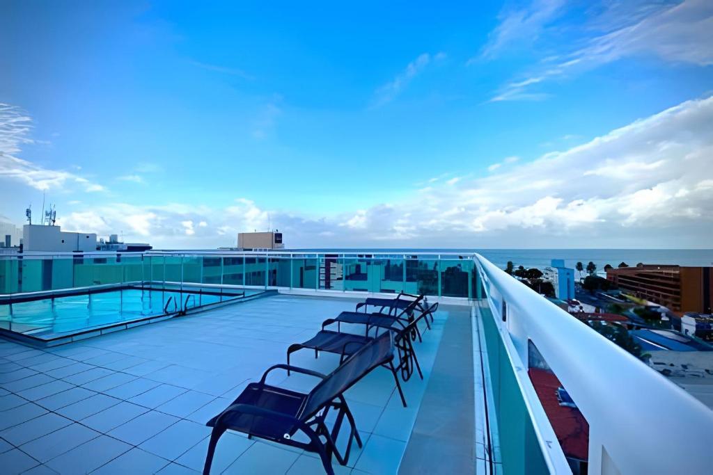 a row of chairs sitting on the roof of a building at 10ª Pirâmide Manaíra by Allmare Apartamentos in João Pessoa