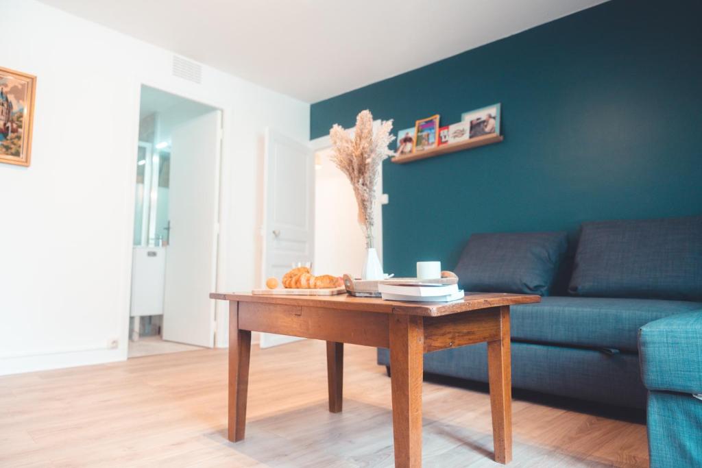 un salon avec un canapé bleu et une table dans l'établissement Le Nœud du Diable - T3 spacieux, à Tours