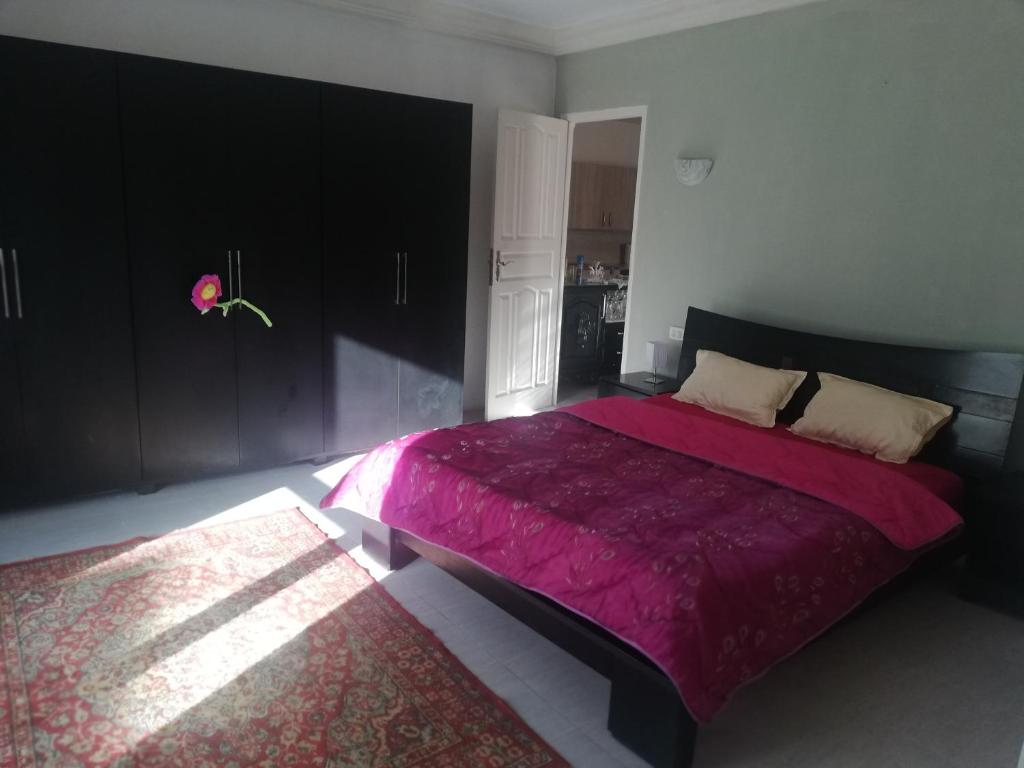 um quarto com uma cama grande e um cobertor roxo em Darna em El Haouaria
