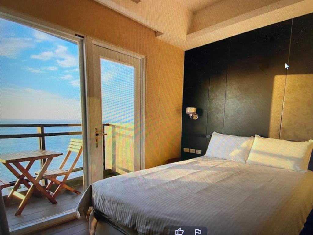 馬公市的住宿－家翔琳海景二館 ，一间卧室配有一张床,阳台配有桌子