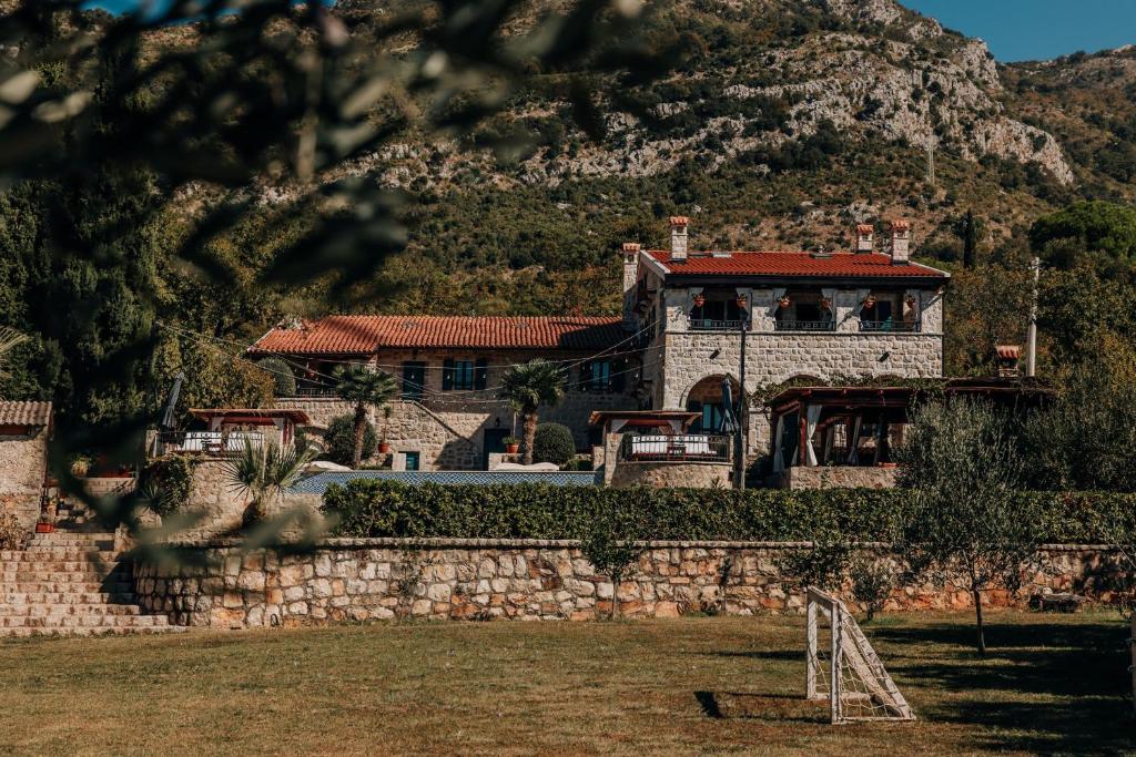 a house in front of a mountain at Talići Hill - Rustic Villas in Sutomore