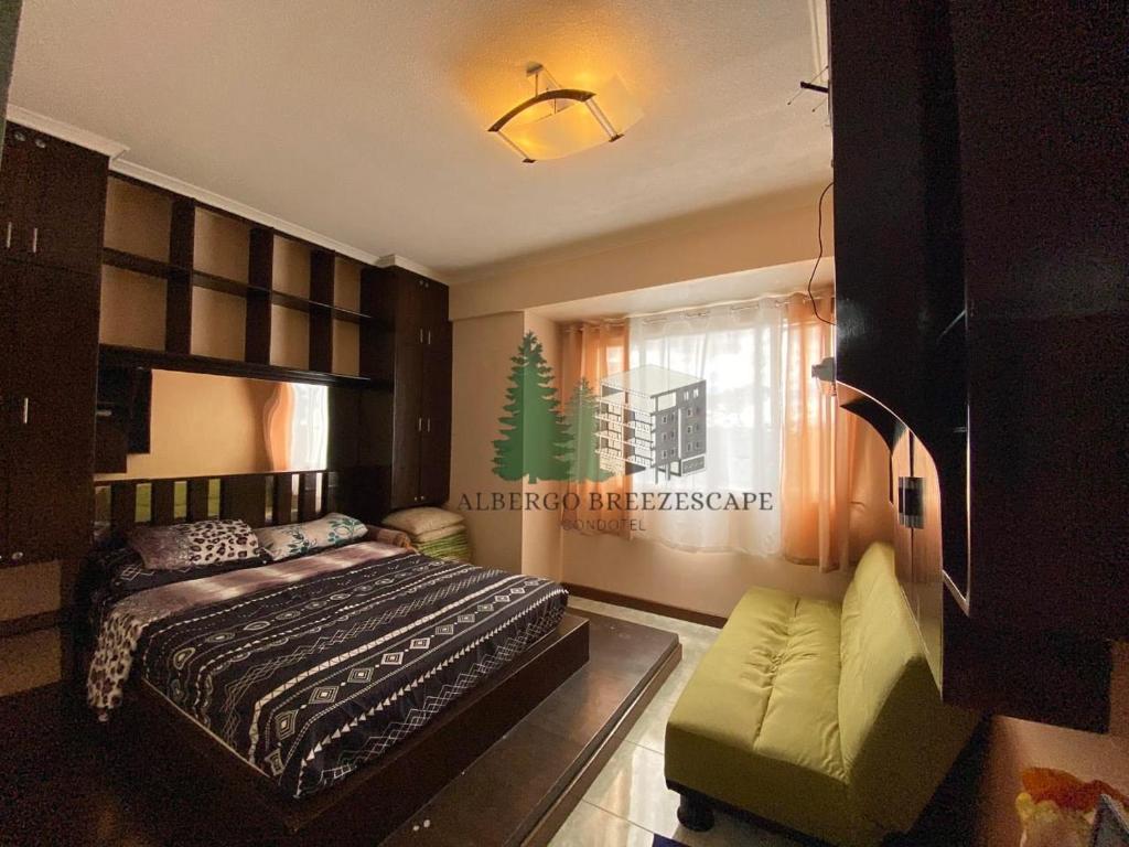 een slaapkamer met een bed en een bank bij Albergo Breezescape Condotel in Baguio