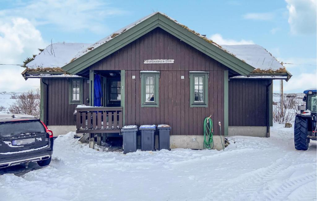 a small house with a car parked in the snow at Cozy Home In Rrvik With Wi-fi in Rørvik