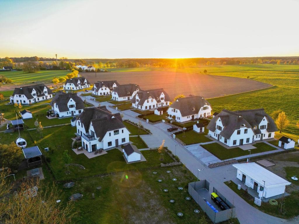- une vue aérienne sur un grand domaine avec des maisons blanches dans l'établissement Inseldomizil Stolpe - Urlaub unter Reet auf Usedom, à Stolpe auf Usedom