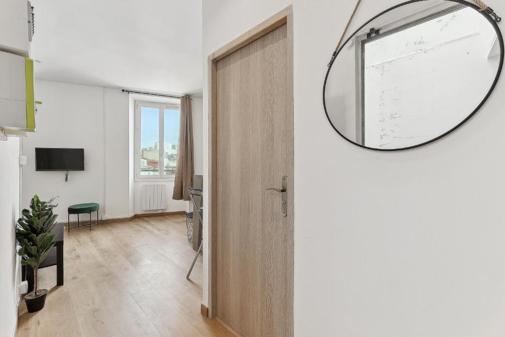 un couloir avec une porte et un miroir mural dans l'établissement La Pépite de la Joliette - Central & Lumineux - Les Frères de la Loc', à Marseille