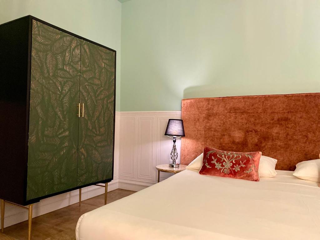- une chambre avec un lit et un mur vert dans l'établissement MURANO Place - MISTRO House, à Murano