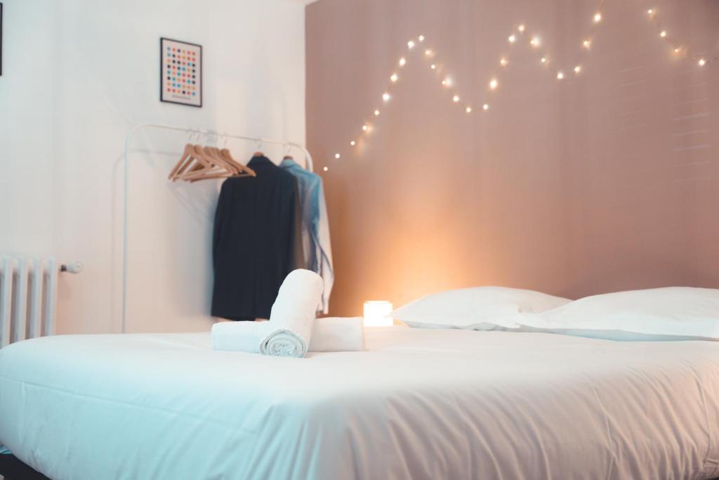 - une chambre avec un lit blanc et des lumières sur le mur dans l'établissement Confortable T3, proche Halles, à Tours