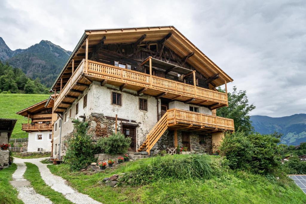 a house with a wooden balcony on top of it at Bergchalet Lanthalerhof in San Martino