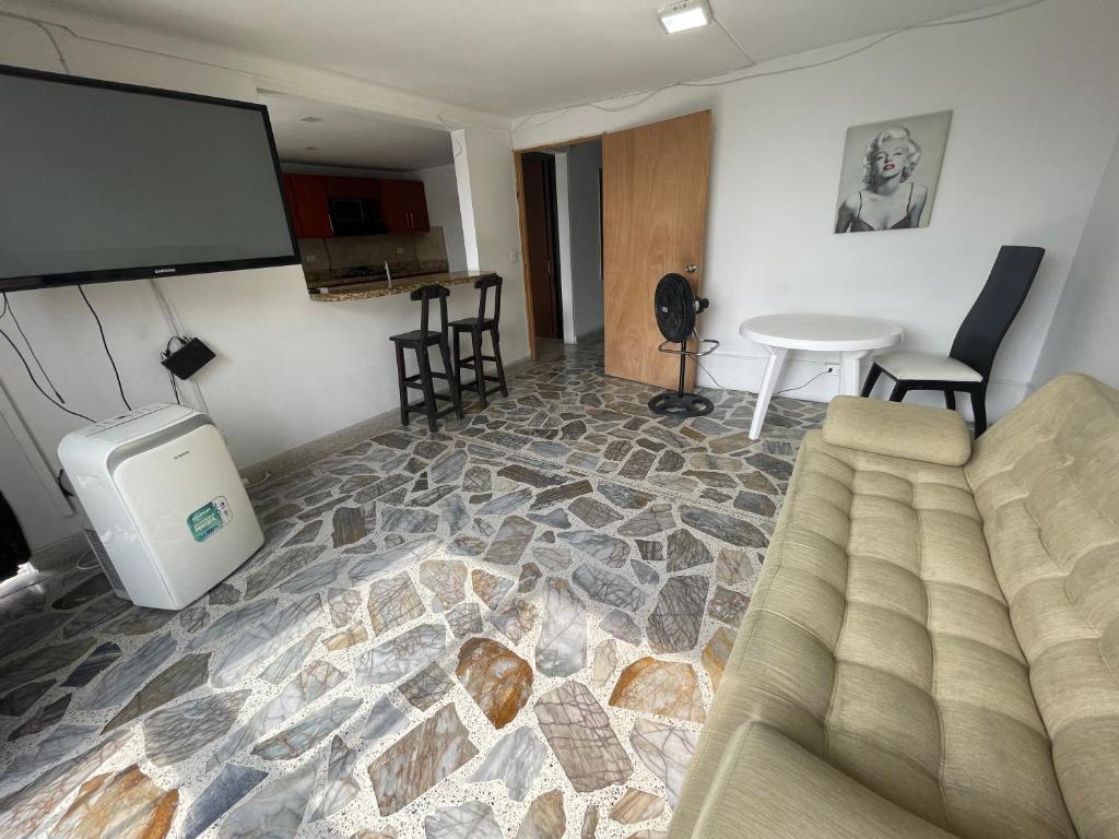 sala de estar con sofá y pantalla de proyección en Apartamento cómodo , grande , céntrico , bien ubicado apto 303, en Medellín