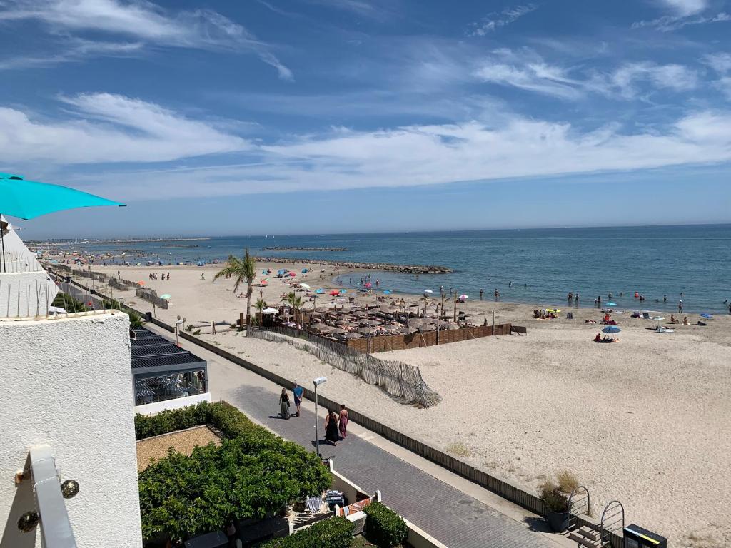 une vue d'une plage avec des gens et l'océan dans l'établissement Appartement 1ere ligne Palavas les flots, à Palavas-les-Flots