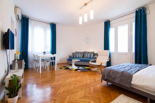 a bedroom with a bed and a couch and a table at Cosy Studio Apartment 2 in Zagreb